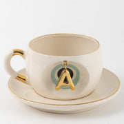 Cream tea mug set with gold letter A charm and saucer, Nile green accents
