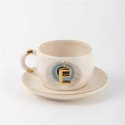 Tea mug with saucer, white ceramic, gold trim, blue medallion letter E
