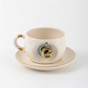 Tea mug with saucer, white ceramic, gold trim, blue medallion letter G