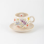 Porcelain coffee cup and saucer set with small floral hearts and gold rim accents