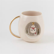 White ceramic mug with gold handle, snowman and pine trees print on front