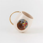 Ceramic mug with gold handle, tilted view showing balloon dog artwork