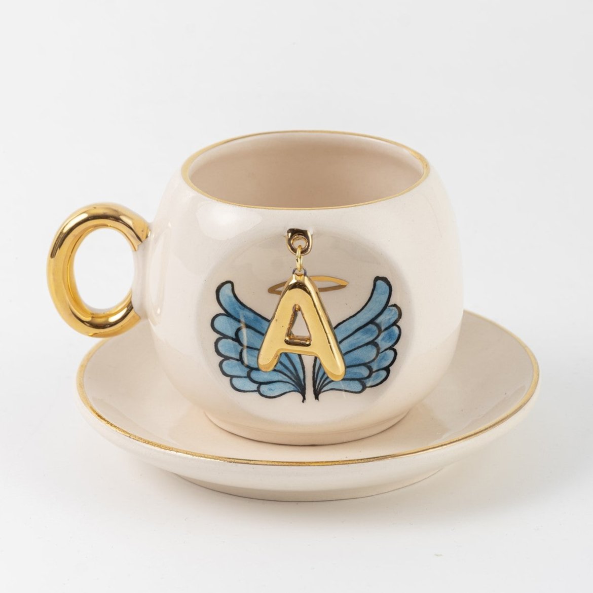Ceramic coffee cup and saucer with gold A, blue angel wings, and curved gold handle