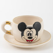 White tea mug and saucer set with Mickey Mouse face, gold accents