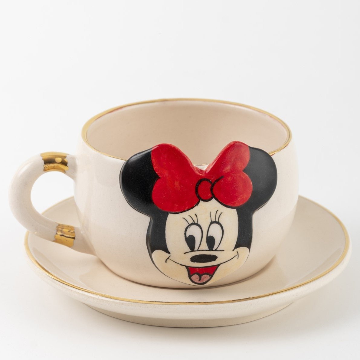 White ceramic tea cup and saucer set with gold trim and Minnie Mouse face