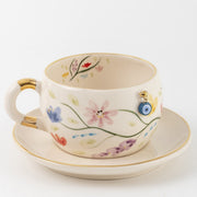 Tea cup and saucer set in white with multicolor flowers and gold trim