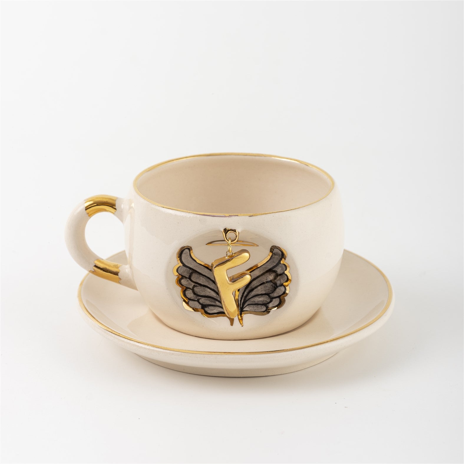 Porcelain mug and saucer with angel wing badge and gold letter F, cream base