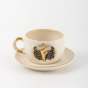 Porcelain mug and saucer with angel wing badge and gold letter F, cream base