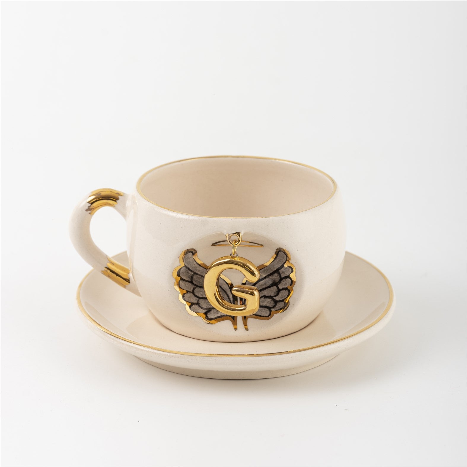 Porcelain mug and saucer with angel wing badge and gold letter G, cream base