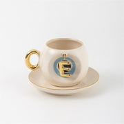 Ceramic Turkish coffee cup and saucer with gold handle, blue letter E charm