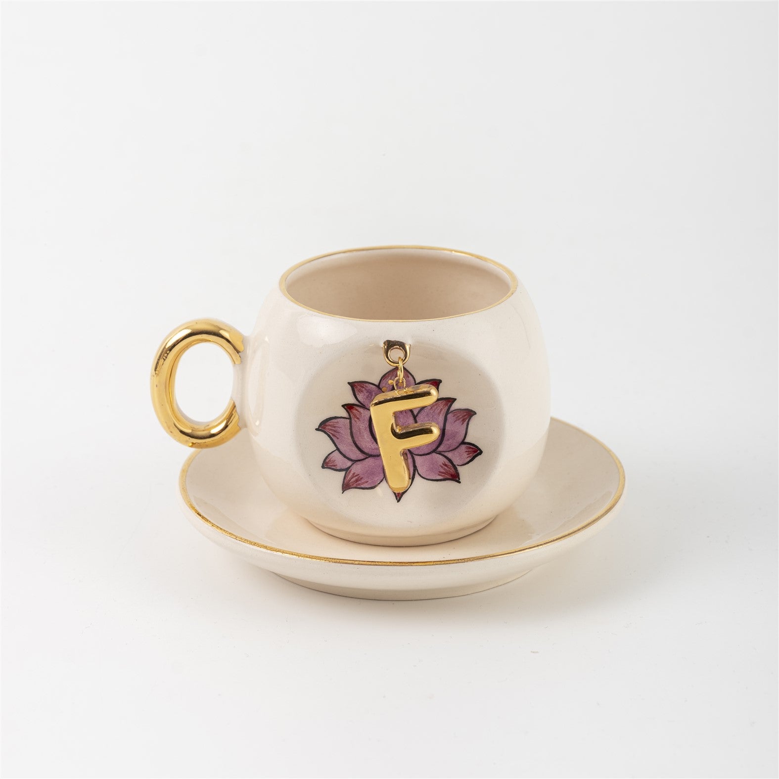 Ceramic coffee cup and saucer with gold handle, lotus letter F emblem on front