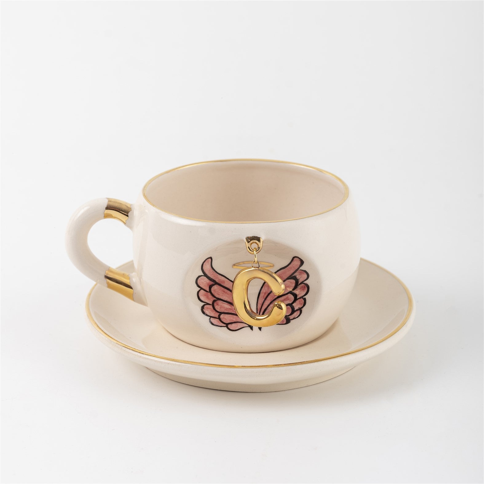 Porcelain teacup with matching saucer, gold rim, and angel-wings letter print on front