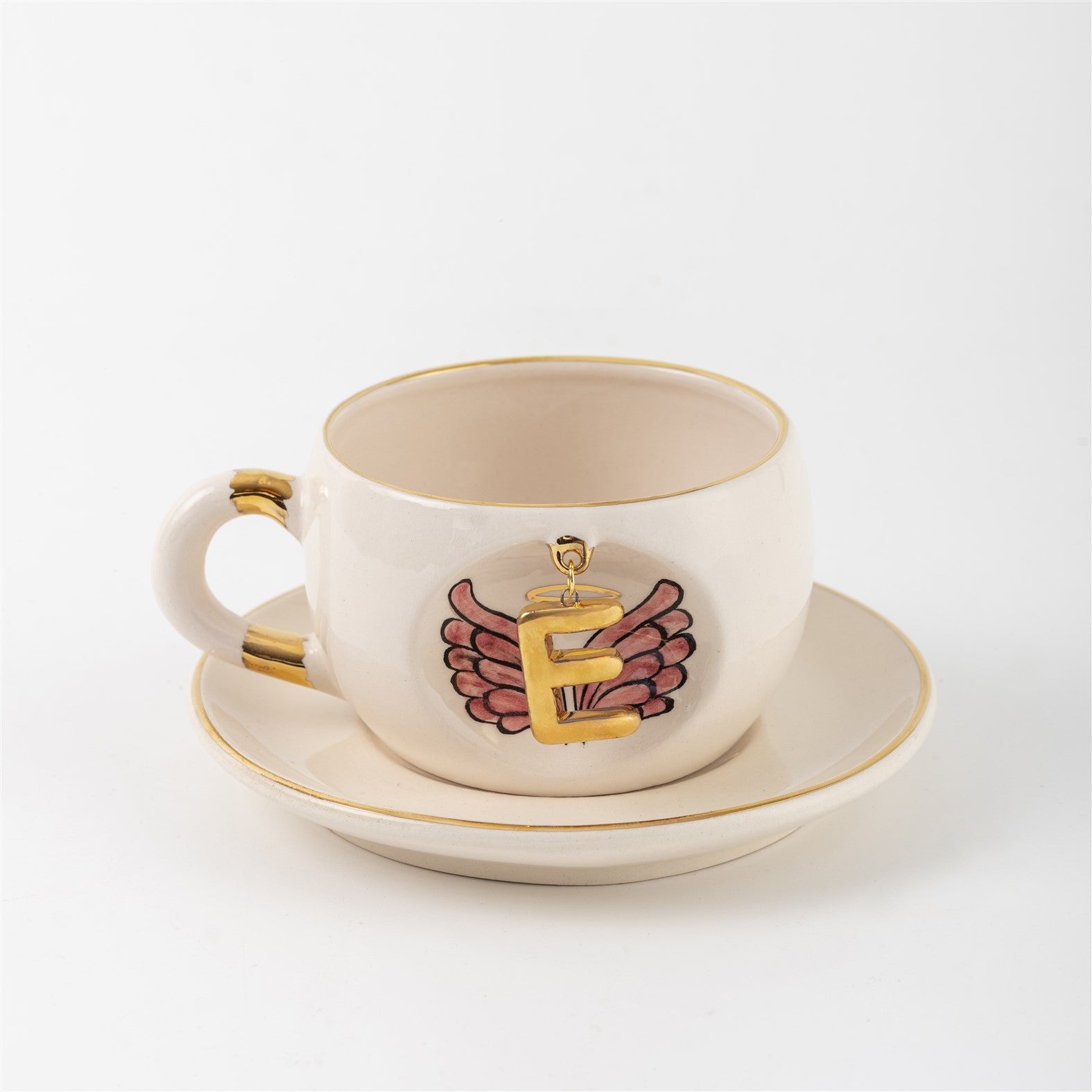 Porcelain mug and saucer with gold detailing, white glaze, and angel-wings letter graphic