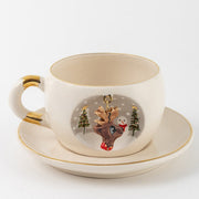 White deer mug with gold handle and gold-toned charm; reindeer illustration on saucer