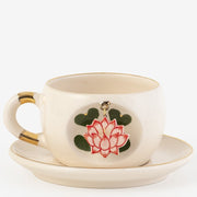 Cream lotus mug set with gold rim; red flower and green leaves on cup