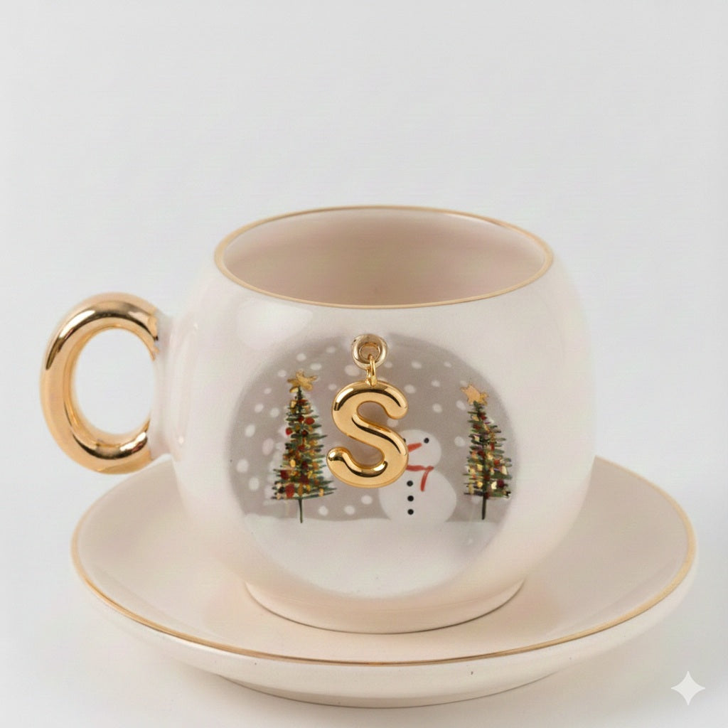 Porcelain coffee cup and saucer with gold letter S charm, snowman and forest trees.