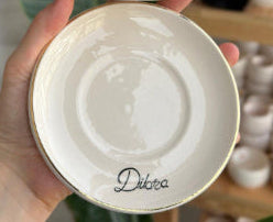 Enlarged example of gold handwriting on a saucer rim