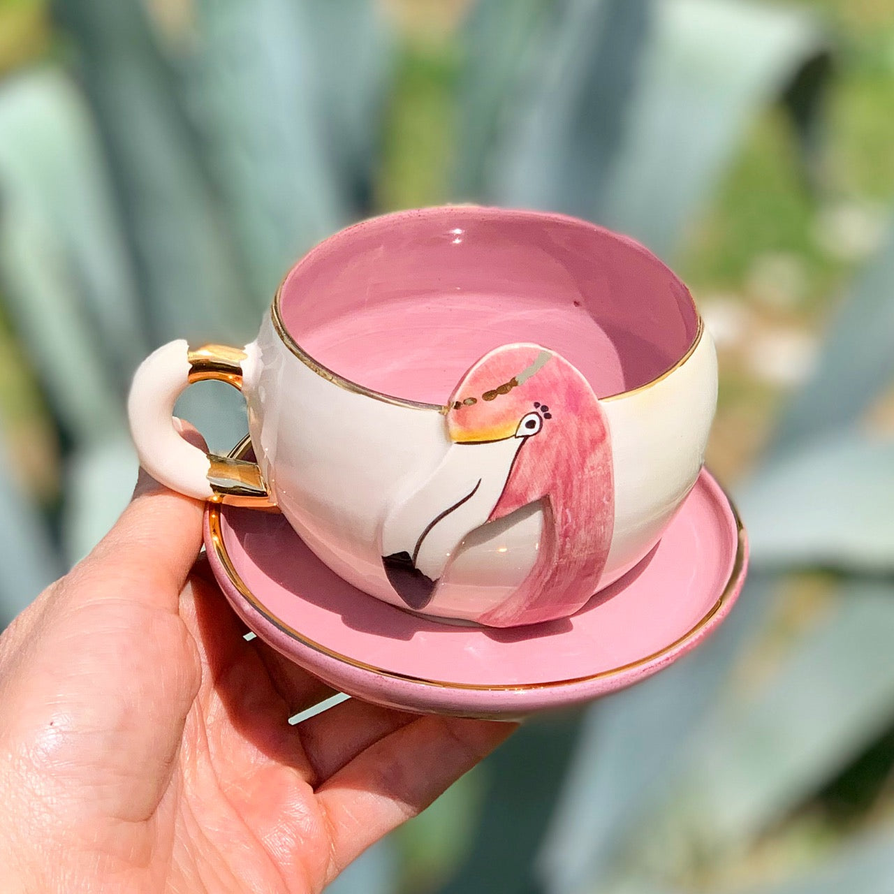 Pink flamingo tea mug on saucer, gold handle detail, glossy ceramic