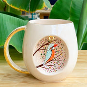 Kingfisher mug, white ceramic with gold handle and colorful bird artwork on front